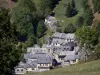 Pyrenees landscapes - Church bell tower and houses in the village of Aspin-Aure, pasture and trees