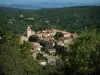 Ramatuelle - Trees in foreground with view of houses and the church bell tower in the village, forest, the Mediterranean Sea and the hills of the coast in background