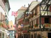 Ribeauvillé - Suspended flags and colourful houses with windows decorated with geranium flowers