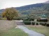 Ruta Napoléon - Pradera de la reunión con la estatua ecuestre de Napoleón I, los árboles con los colores del otoño en el fondo, la ciudad de Laffrey