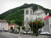 Saint-Claude - Saint-Pierre cathedral, flags, street, buildings and trees; in the Upper Jura Regional Nature Park