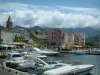 Saint-Florent - Marina con barcos, torre de la iglesia y las casas en la localidad