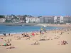 Saint-Jean-de-Luz - Zandstrand met toeristen, de Atlantische Oceaan en de gevels aan het strand van het resort