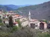 Saint-Pierreville - Parque Natural Regional de los Monts d'Ardèche - Castaño País: torre de la iglesia y las casas de la aldea en un entorno arbolado