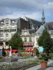 Saint-Quentin - Parterres de fleurs, arbustes en pots, et façades de la place de l'Hôtel de Ville ; clocher de la basilique Saint-Quentin dominant l'ensemble