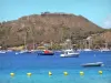 Les Saintes - Les Saintes bay with boats, houses of Terre-de-Haut and the Napoléon fort at the top of the Mire hill