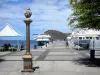 Les Saintes - Landing stage of Terre-de-Haut and its moored ships, bust of Marianne, and café terrace at the water's edge