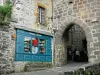 Salers - Door of the Belfry, vestige of the old medieval rampart, and storefront of a souvenir shop