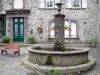 Salers - Fountain and flowery facade of a stone house