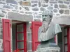 Salers - Bust of Pierre-Ernest Tyssandier d'Escous and facade of a stone house with red shutters