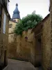 Sarlat-la-Canéda - Narrow street of the medieval old town with view of the bell tower of the Saint-Sacerdos cathedral, in Périgord