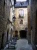 Sarlat-la-Canéda - Stone houses, lampposts and line of tables