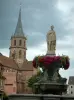 Soultz - Flower-bedecked fountain and Saint-Maurice church