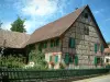 Sundgau - Jardín y la casa de entramado de madera con persianas verdes (pueblo Riespach)