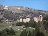 SuperDévoluy - Buildings of the ski resort, trees and mountain, in spring; in Dévoluy