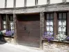 Uzerche - Old house with wood sides with windows decorated with flowers