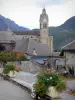 Valbonnais - Village in the Valbonnais area: church bell tower, roofs of houses and flowers, mountains in the background