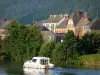 Vale do Meuse - Parque Natural Regional das Ardenas: barco navegando no rio Meuse; fachadas de casas e árvores à beira da água
