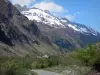 Valgaudemar - Valle Valgaudemar: calle arbolada, techos de las casas de una aldea y las montañas cubiertas de nieve, en el Parc National des Ecrins (macizo de Ecrins)