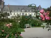 Valloires gardens - Rose in foreground, rose garden (rosebushes), bench and Valloires Cistercian abbey