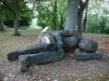 Verneuil-en-Bourbonnais - Sleeping Giant (houten sculptuur) aan de voet van een boom, op Motte Coquet