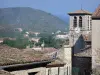 Vogüé - Campanario de la iglesia y las casas de Santa María en el pueblo con una vista del paisaje de las colinas de los alrededores