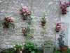 Yèvre-le-Châtel - Flowerpots decorating a stone facade