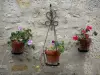 Yèvre-le-Châtel - Flowerpots decorating the facade of a house
